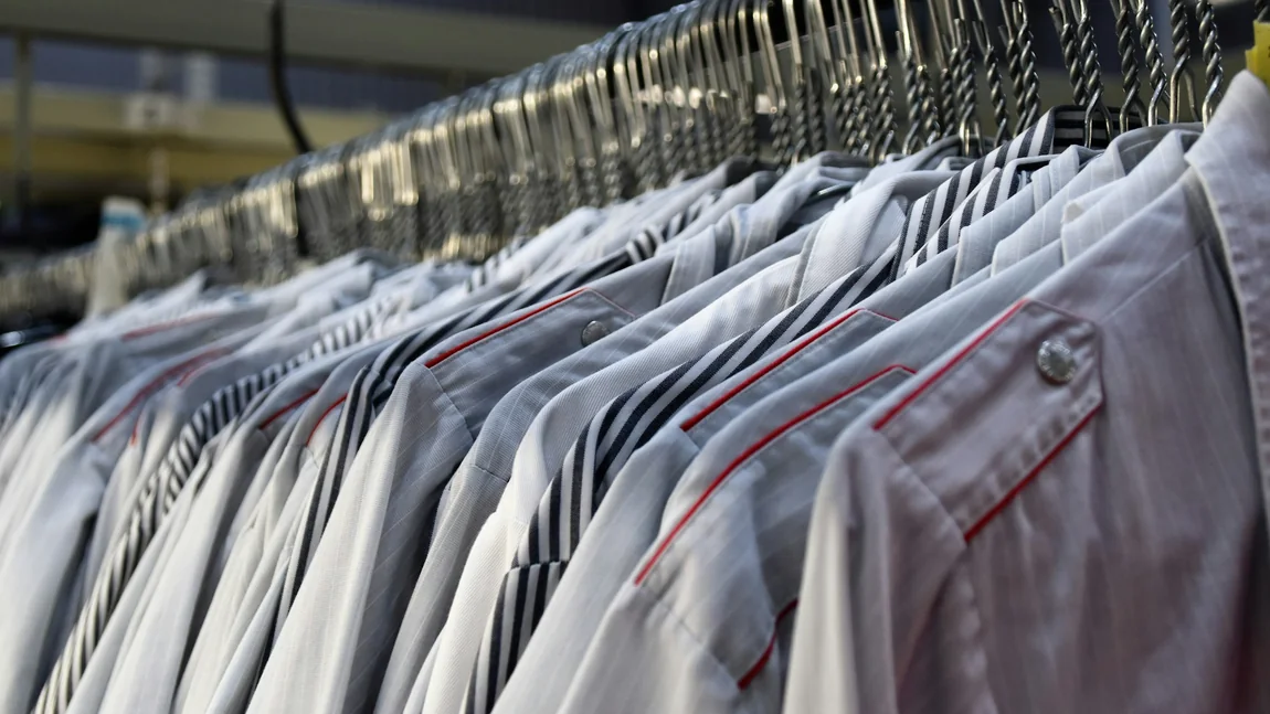 A rail of freshly pressed dress shirts on wire hangers.